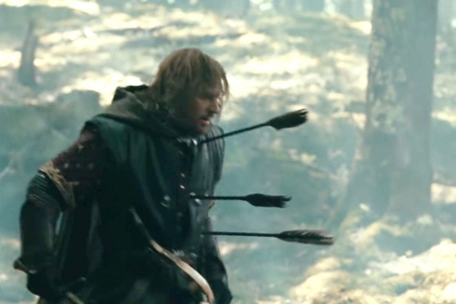 A medieval warrior staggers in a forest, injured with several arrows in his chest