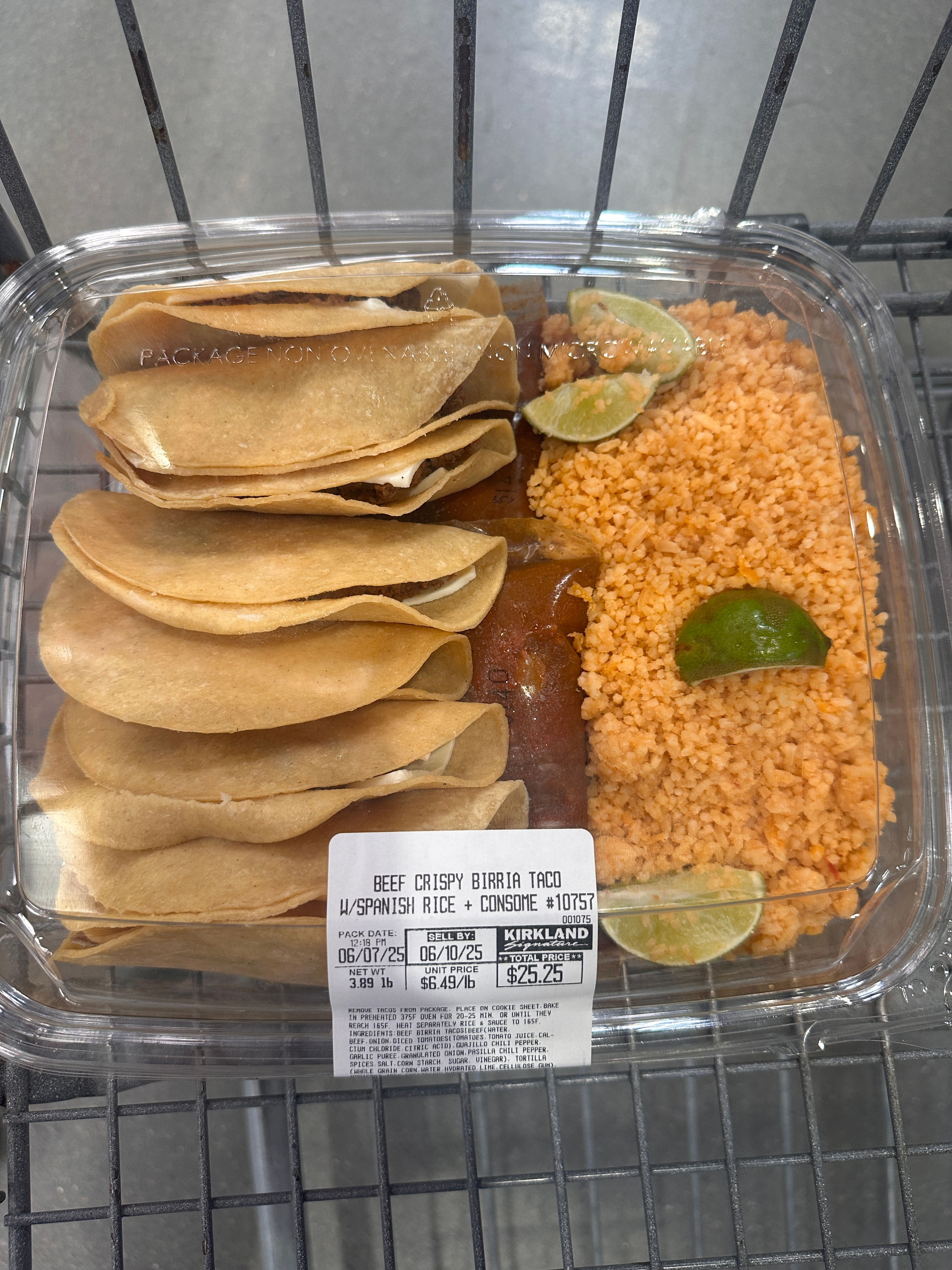 Package of beef crispy birria tacos with Spanish rice, lime wedges, and consommé in a supermarket cart