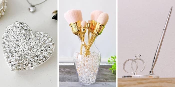 ハート型の宝石付きクラッチバッグ、メイクブラシが入った花瓶、リングホルダーのペンスタンドの展示物。