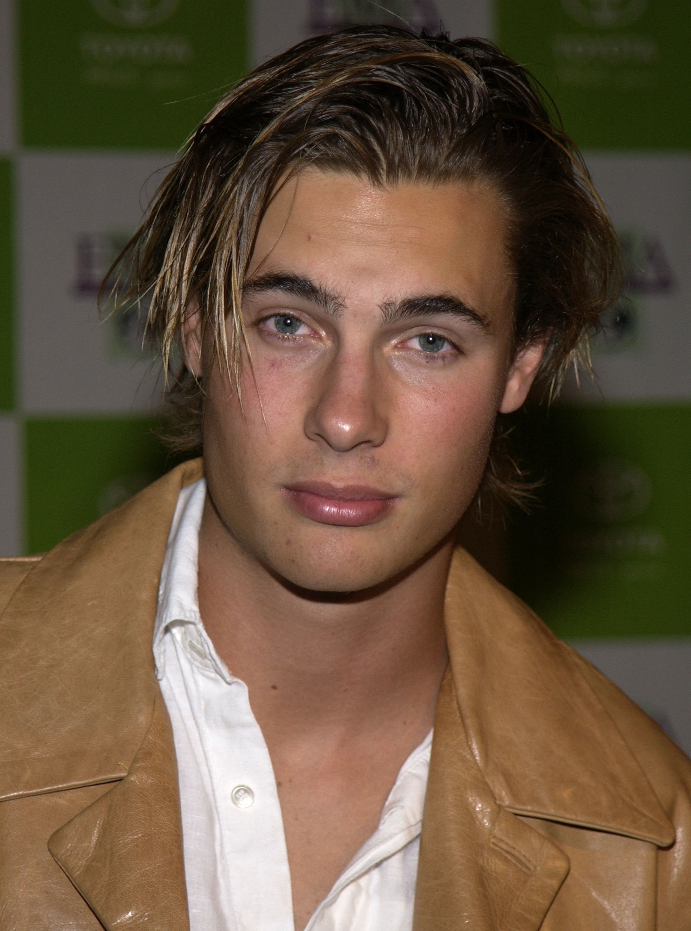 Person with tousled hair in a casual jacket and white shirt at a celebrity event