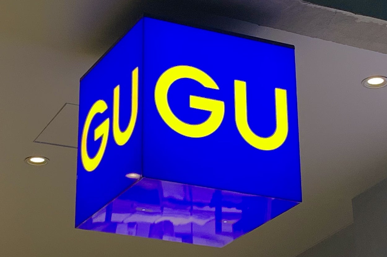 Hanging blue and yellow "GU" store sign