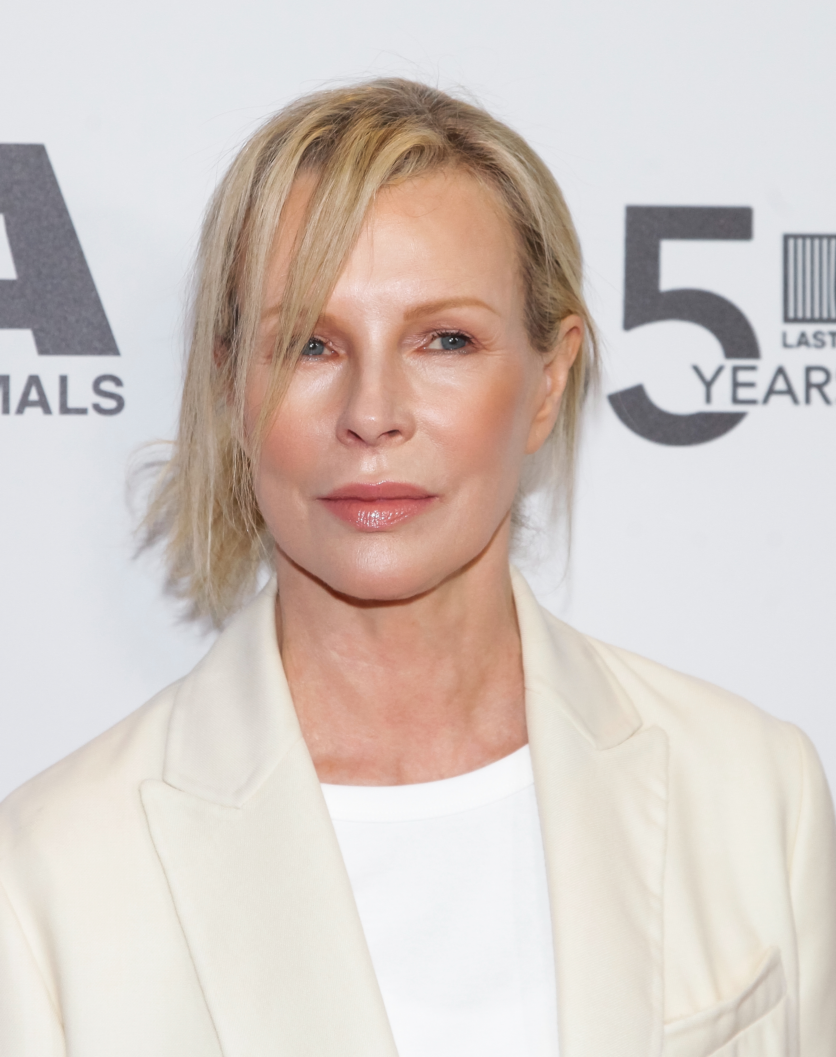 Person in a light blazer and white top at a 50th anniversary event