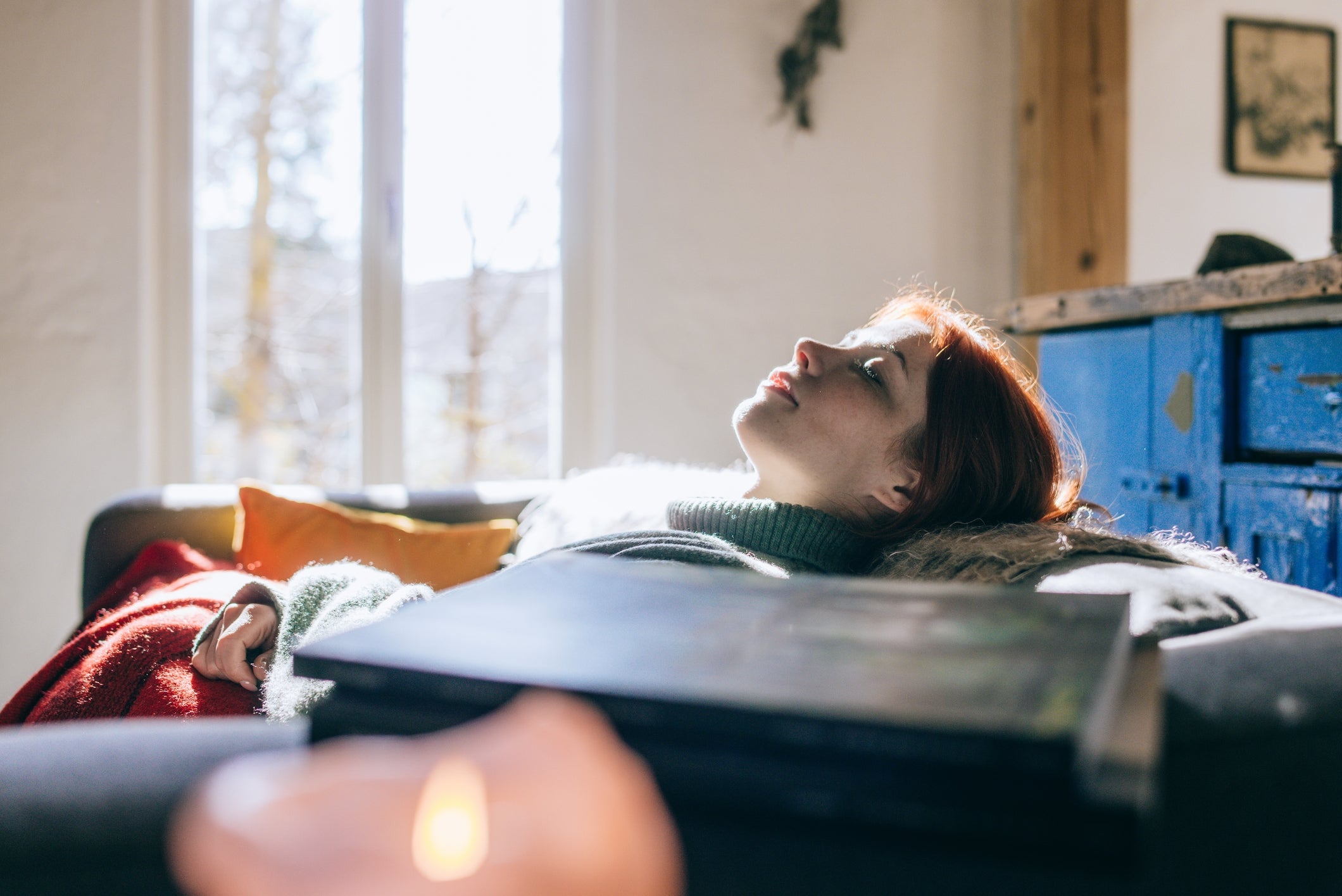Person som ligger på en sofa, stirrer fredelig oppover i en lys stue