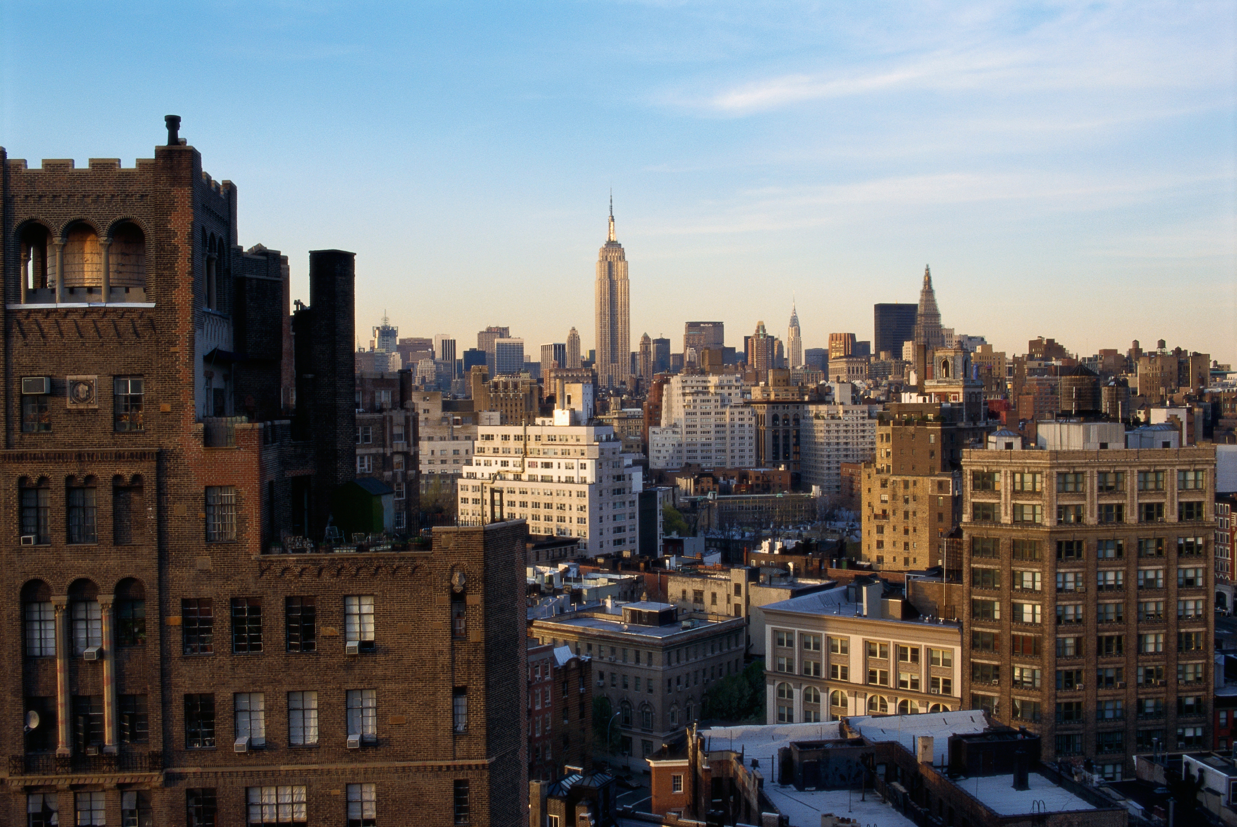 City skyline with a mix of historic and modern buildings, dominated by the Empire State Building in the distance