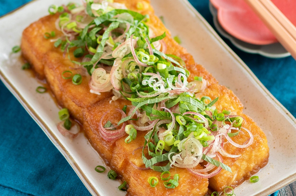 皿に盛られた揚げ豆腐に薬味がたっぷりのった料理。シンプルで美味しそうな見た目。