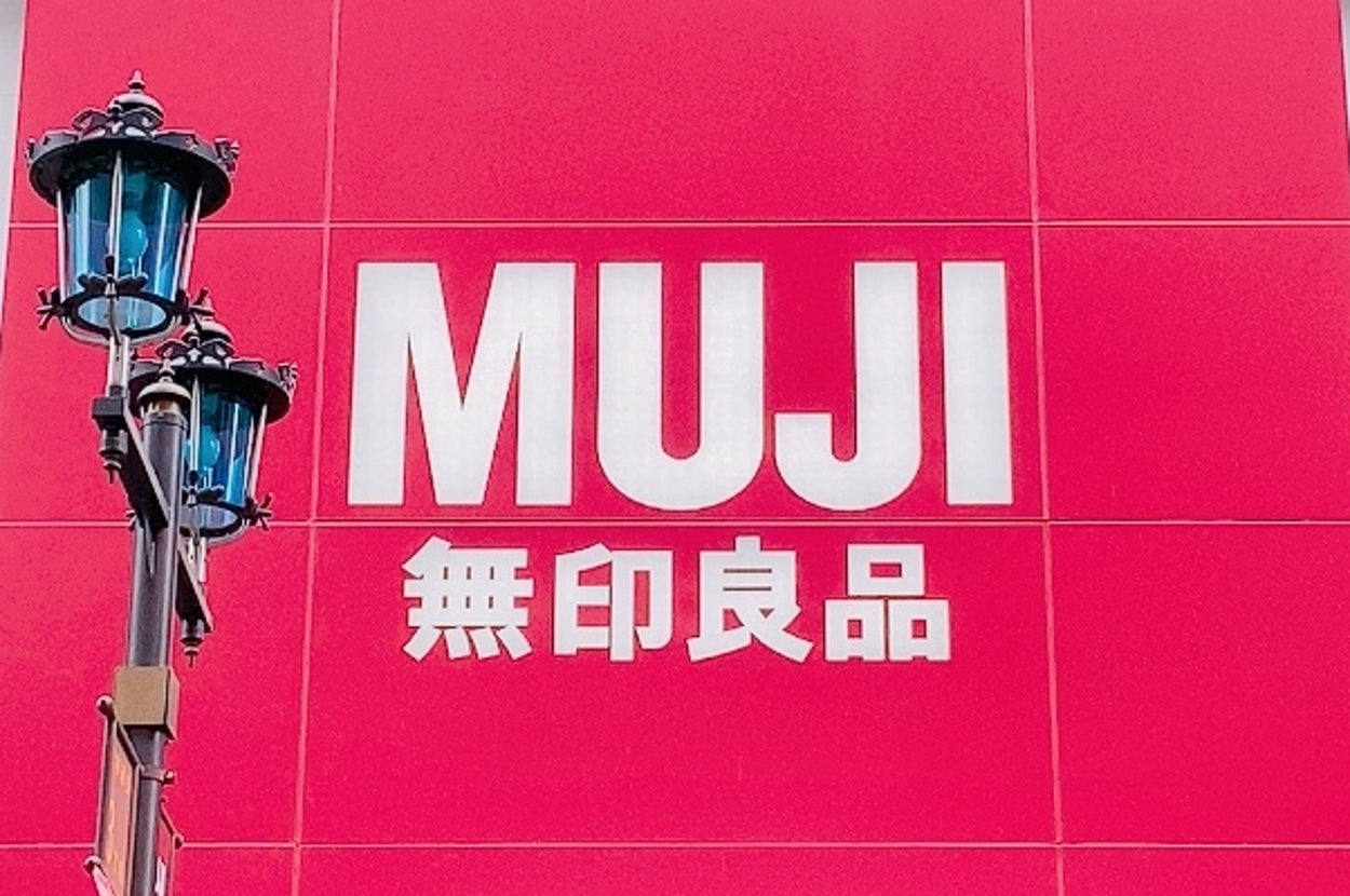 MUJIの店舗入り口。大きな看板にはMUJIと無印良品のロゴが表示されている。
