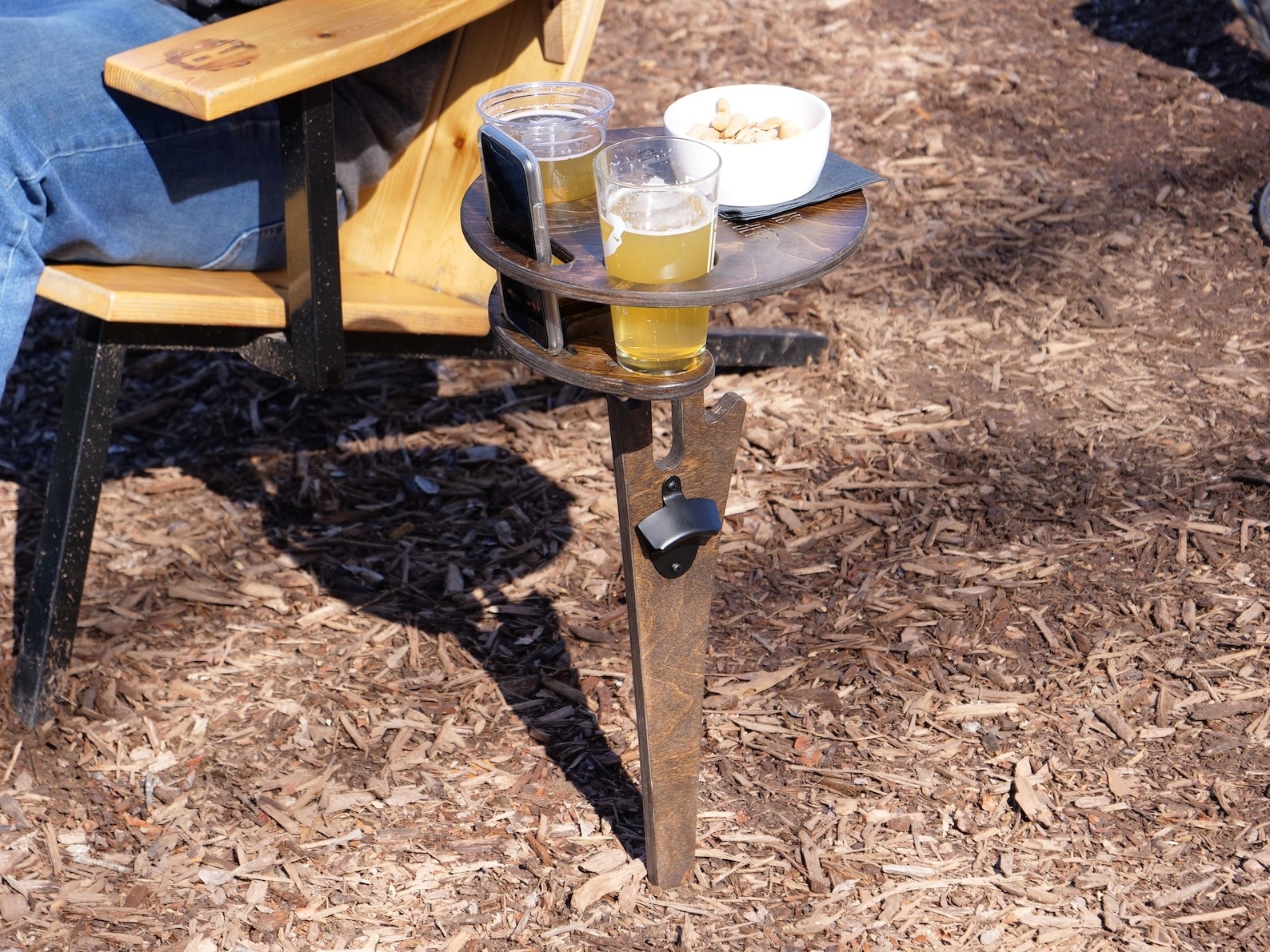 Outdoor drink holder stand with two cups of beer and a bowl of peanuts