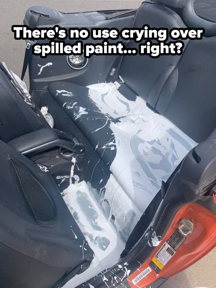 Car seat splattered with white paint, possibly from a spill or accident