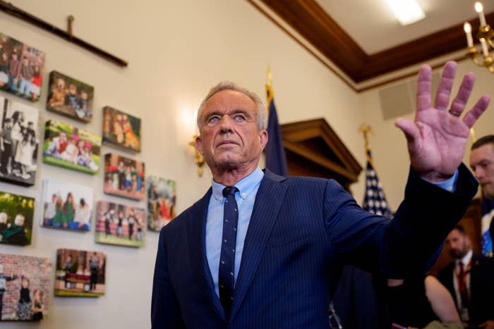 Robert F. Kennedy Jr. waves a goodbye in a government office with flags and pictures