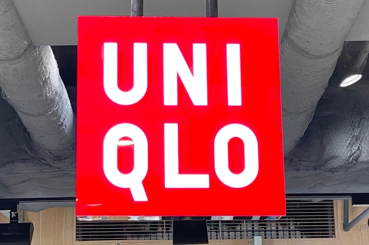 Uniqlo store interior with a suspended red sign displaying the brand name in bold white letters