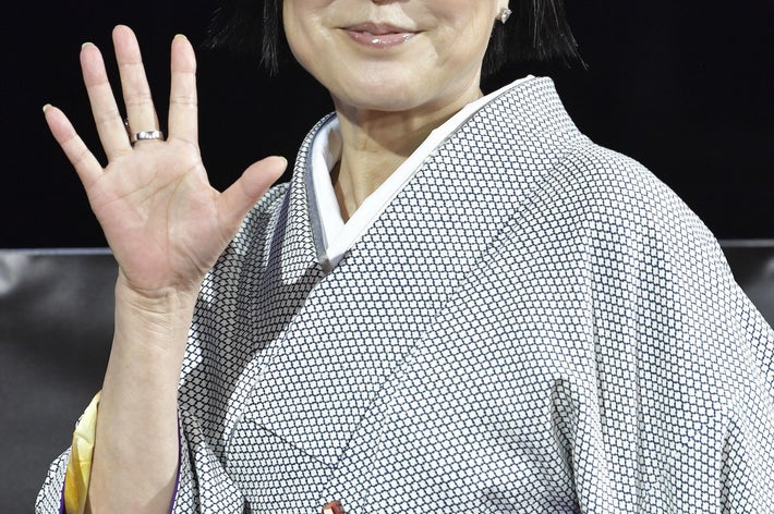 着物を着た女性が手を振っている。シンプルで上品な和装。