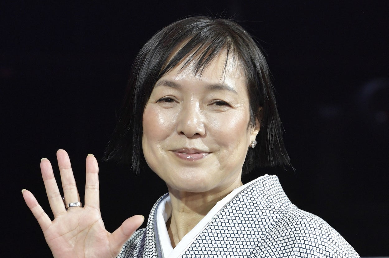 着物を着た女性が手を振っている。シンプルで上品な和装。