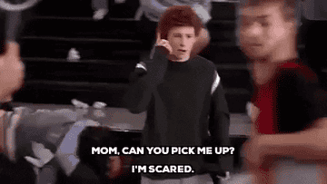 Young person on a phone looks anxious in a chaotic environment. Text: &quot;Mom, can you pick me up? I&#x27;m scared.&quot;