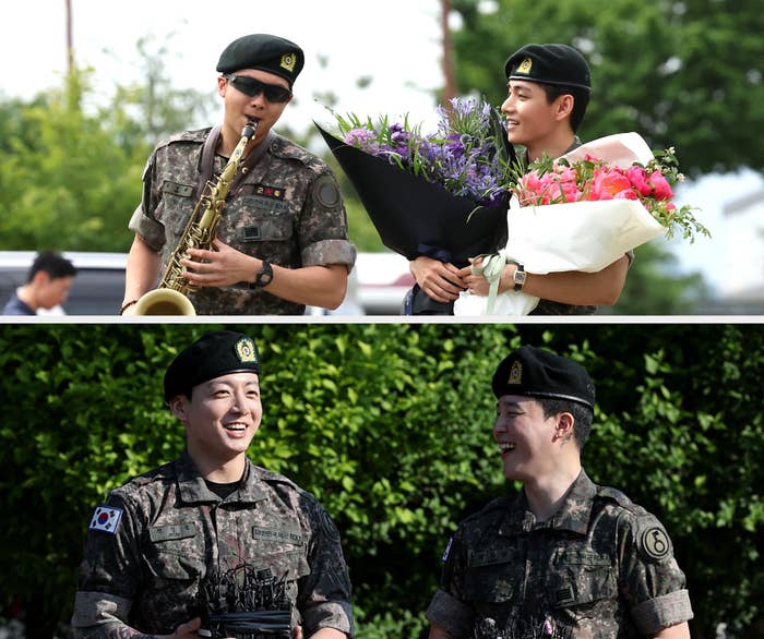 Two men in military uniforms smile; one plays a saxophone, while the other holds flowers