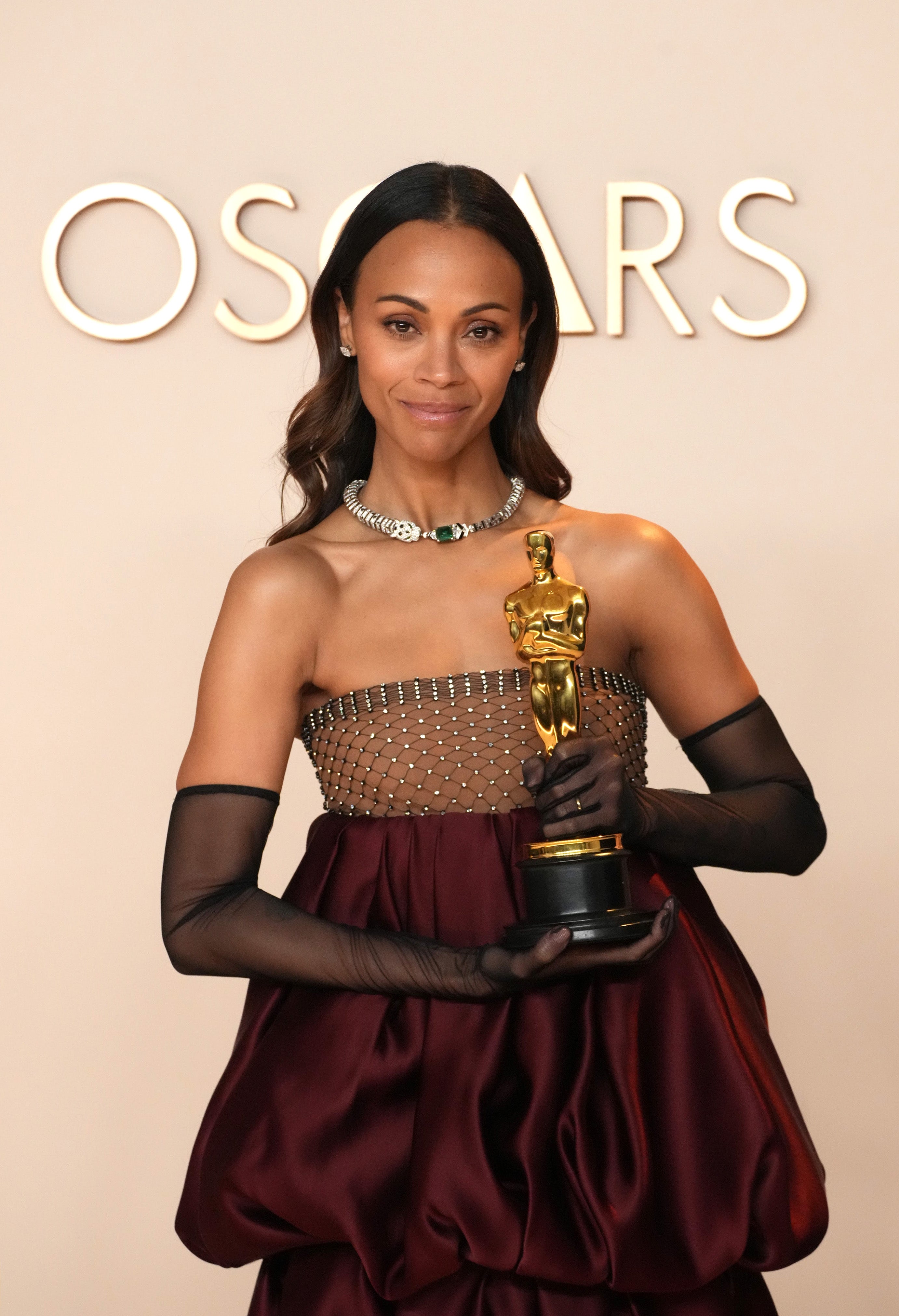 Zoe Saldaña holding an Oscar