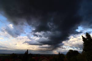 家の近くに雷が落ちる夜の風景。空には光る稲妻が複数本走っている。