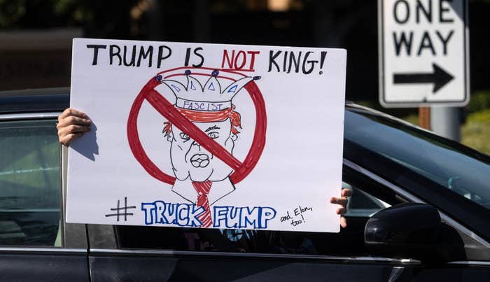Person in car holds a sign with "Trump is NOT king!" and "Fascist" crossed out on Trump's face. Includes hashtag #TruckFump