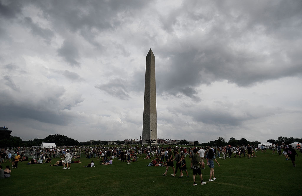 Crowd gathers near the Washington Monument under a cloudy sky