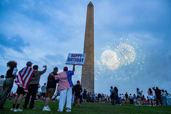 People watch fireworks near the Washington Monument, celebrating a birthday with a sign that says &quot;Happy Birthday. I Love You.&quot;
