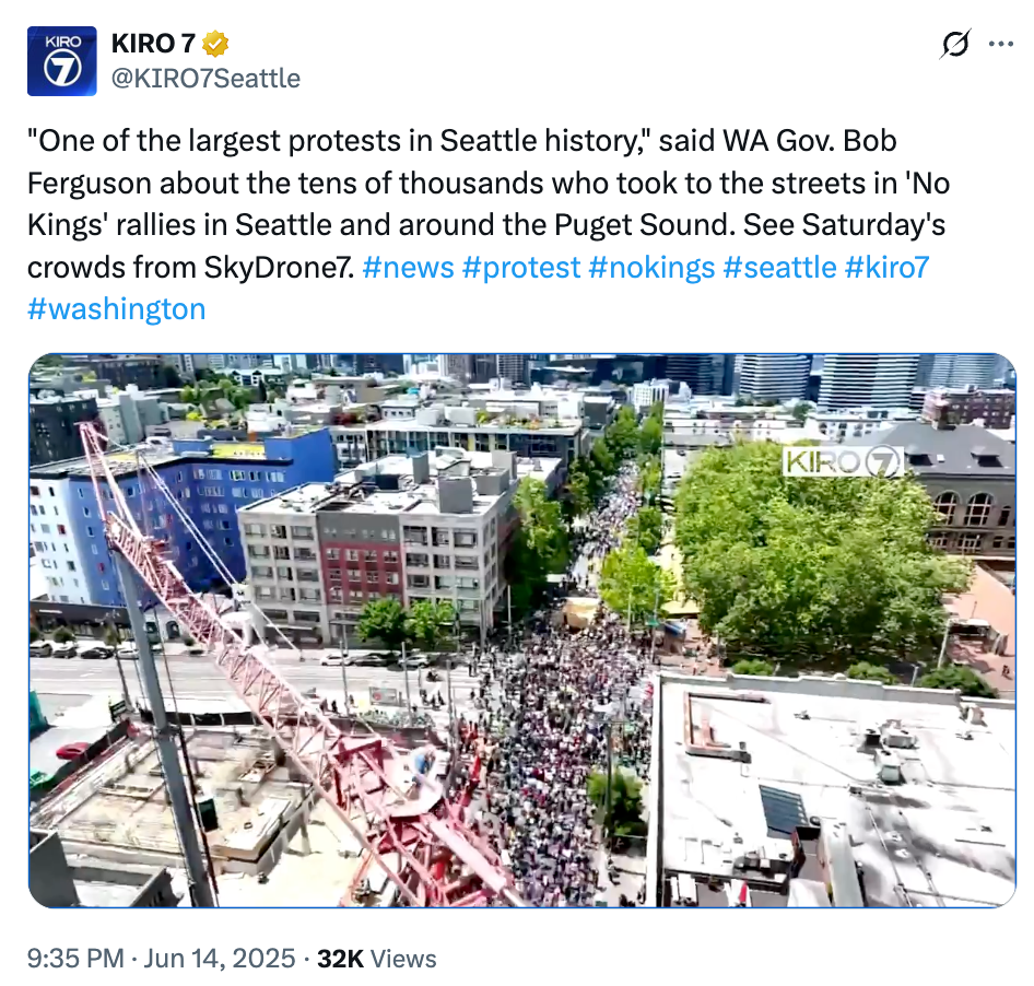 A protest in Seattle draws thousands, seen from above. The crowd fills the streets near construction sites and green spaces