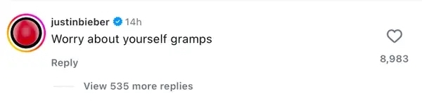 A social media post reply by a verified account saying, "Worry about yourself gramps," with 8,983 likes and 535 replies