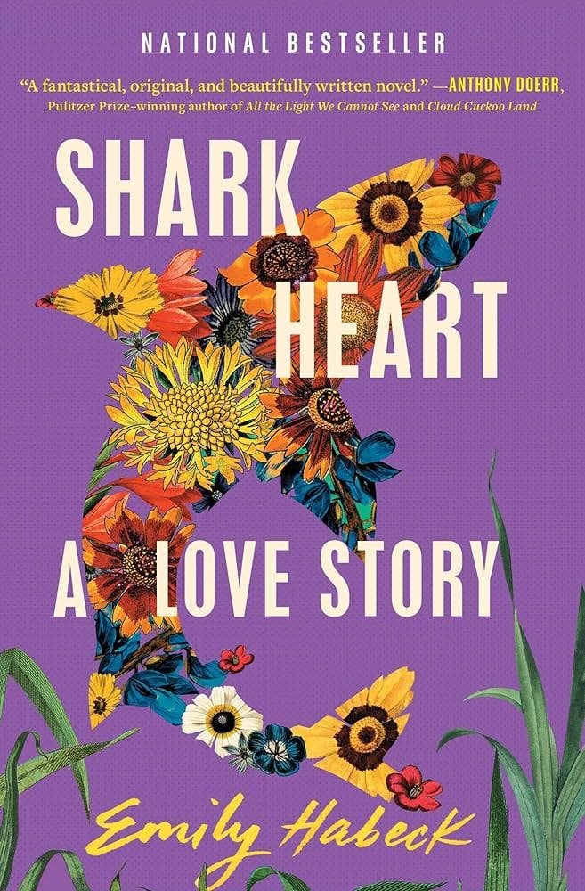 Book cover of &quot;Shark Heart: A Love Story&quot; by Emily Habeck. Features a shark outline filled with flowers on a purple background with Anthony Doerr&#x27;s praise
