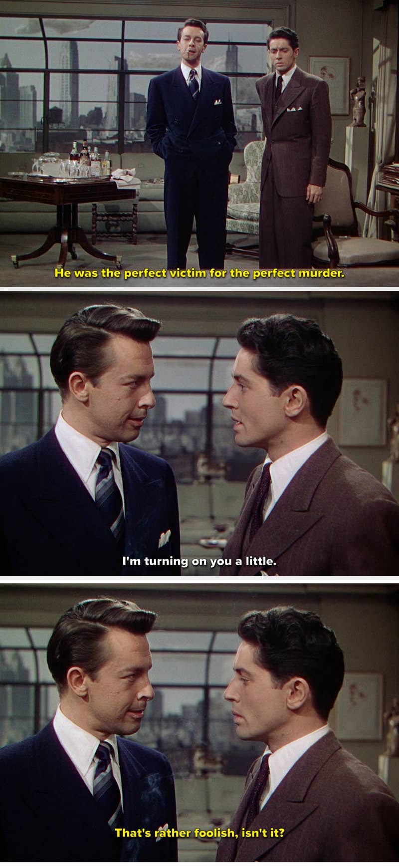 Two men in suits having a conversation indoors, city skyline visible through the window