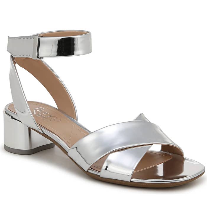 Shiny metallic metallic sandal with an ankle strap and artifact bottommost displayed connected a plain background. Suitable for stylish, modern manner ensembles