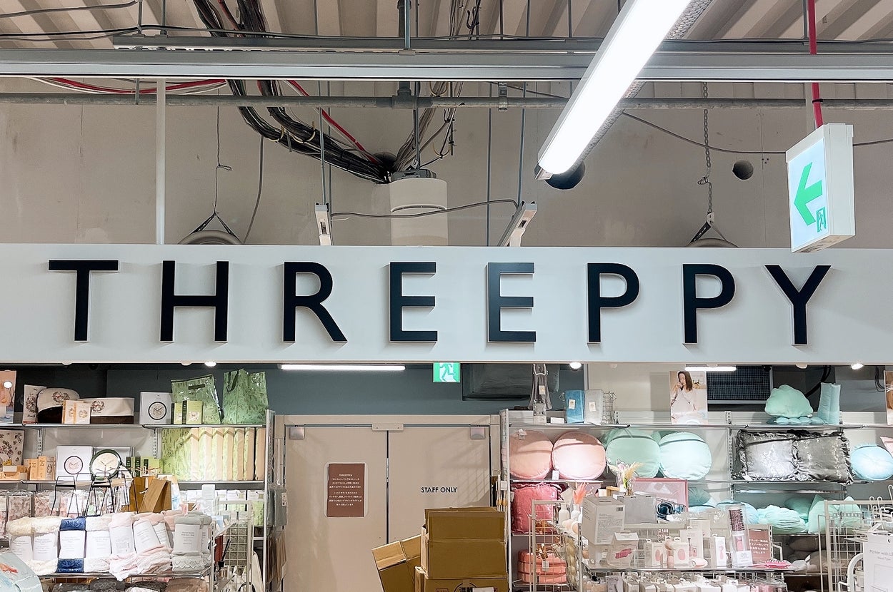 店内の「THREEPPY」看板前に多くの商品が並ぶディスプレイ。