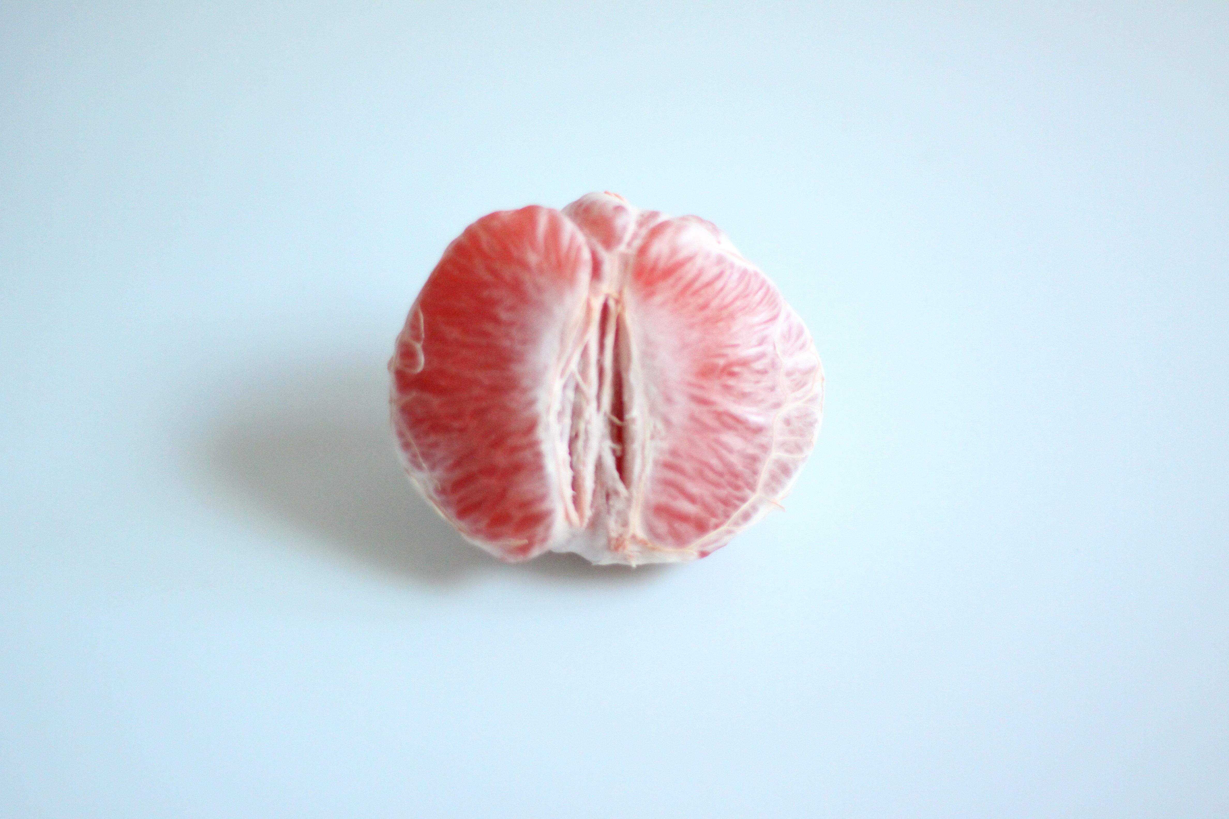 Skrellet grapefrukt halvt hvile på en flat overflate, og viser frem sine saftige segmenter