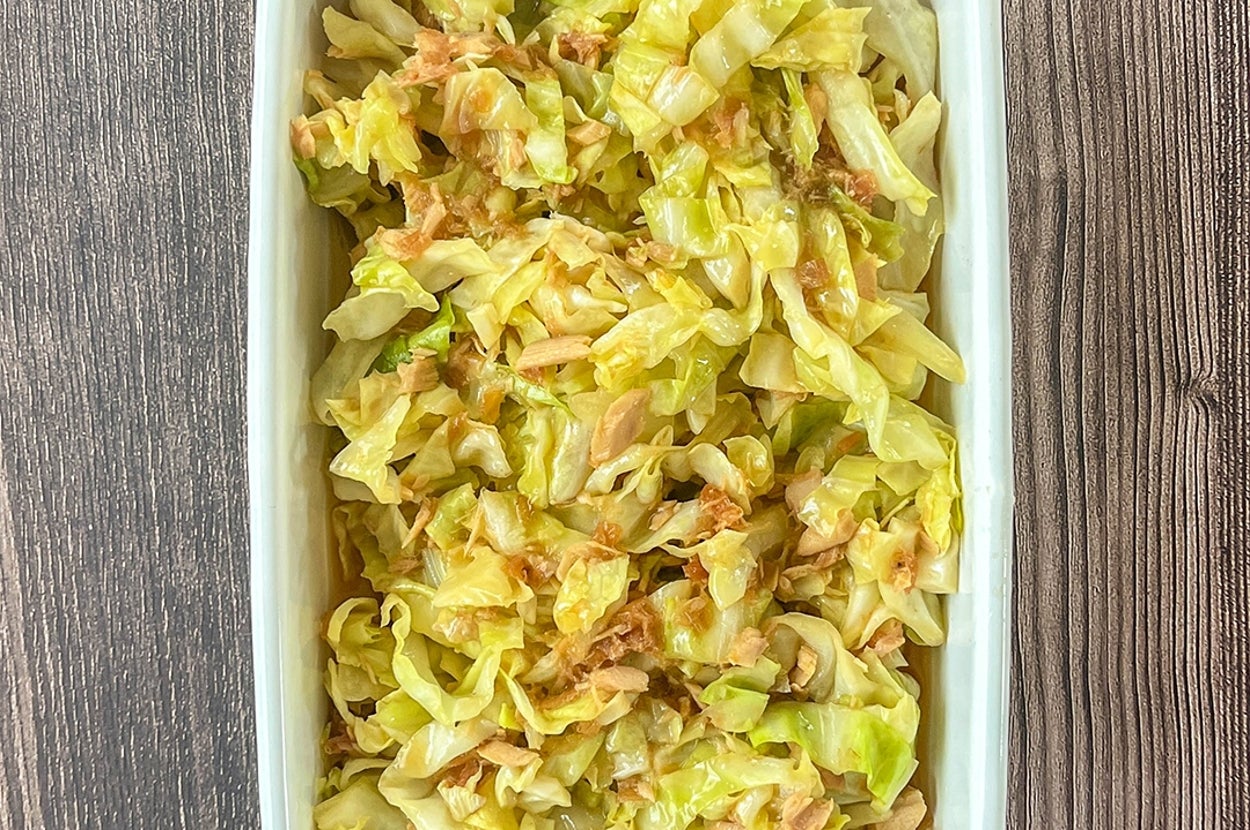 レンジで加熱したキャベツとツナ缶、調味料を混ぜた和え物が白い器に盛られテーブルに置かれている。