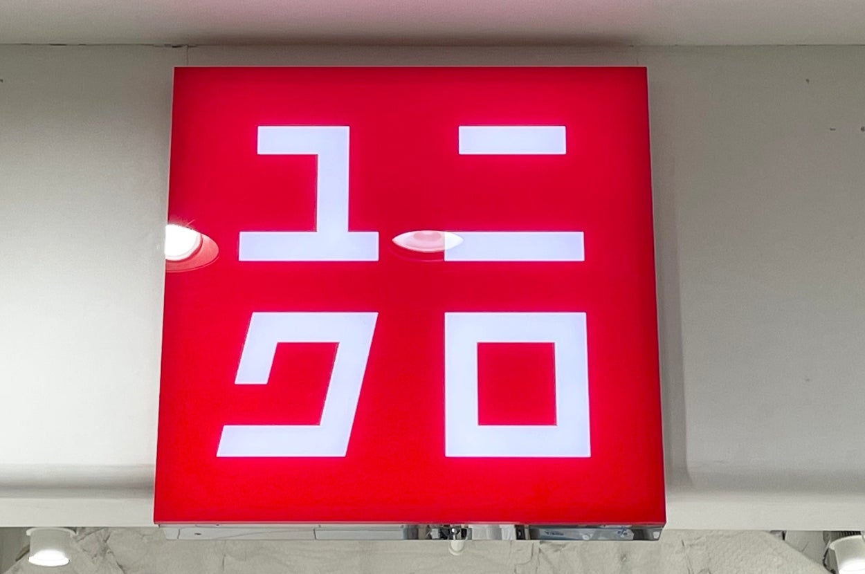 The image shows a Uniqlo store sign with white text on a contrasting square background