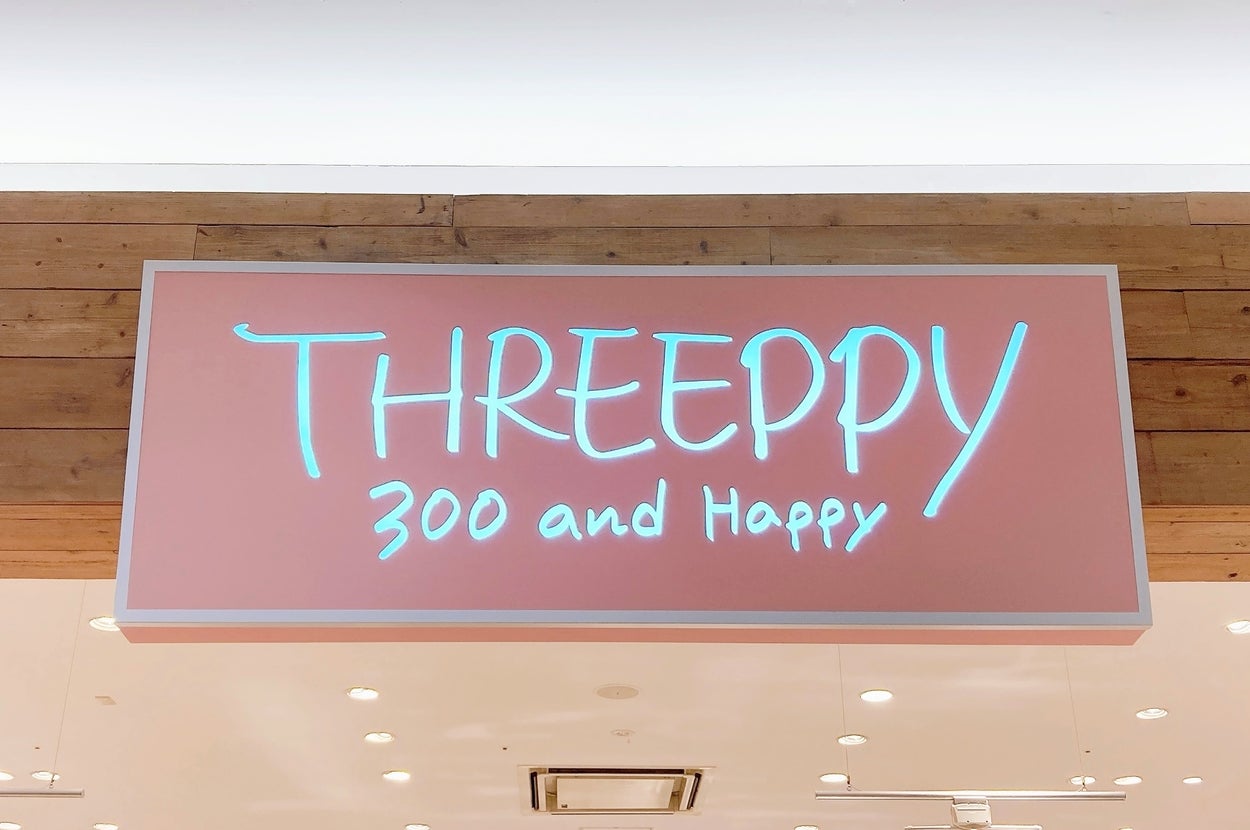 店内の看板に「THREEPPY 300 and Happy」と書かれています。