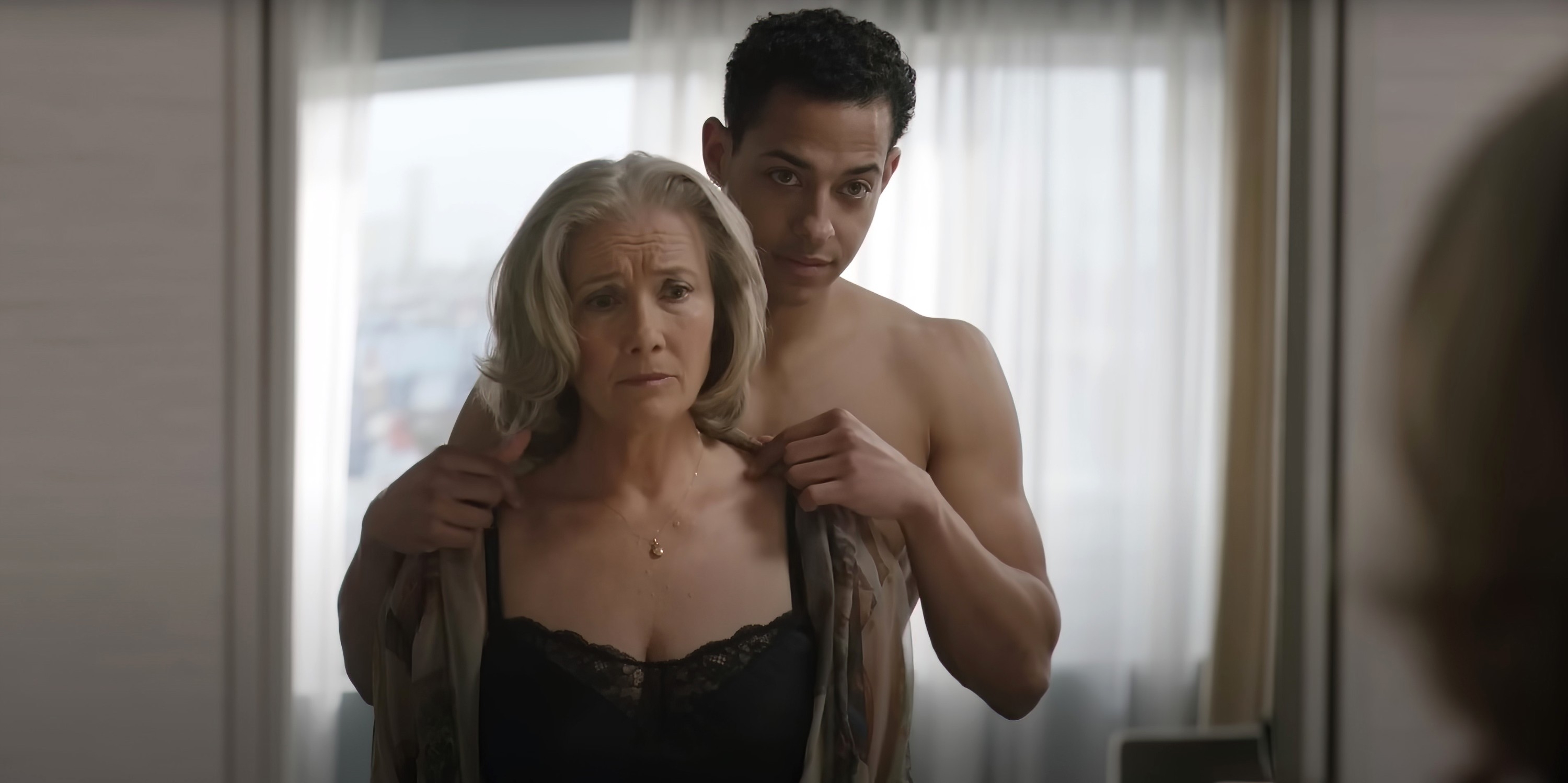 A pistillate   looks acrophobic   successful  a reflector  arsenic  a shirtless antheral   stands down  her, mildly  guiding a overgarment   onto her shoulders successful  a tender moment