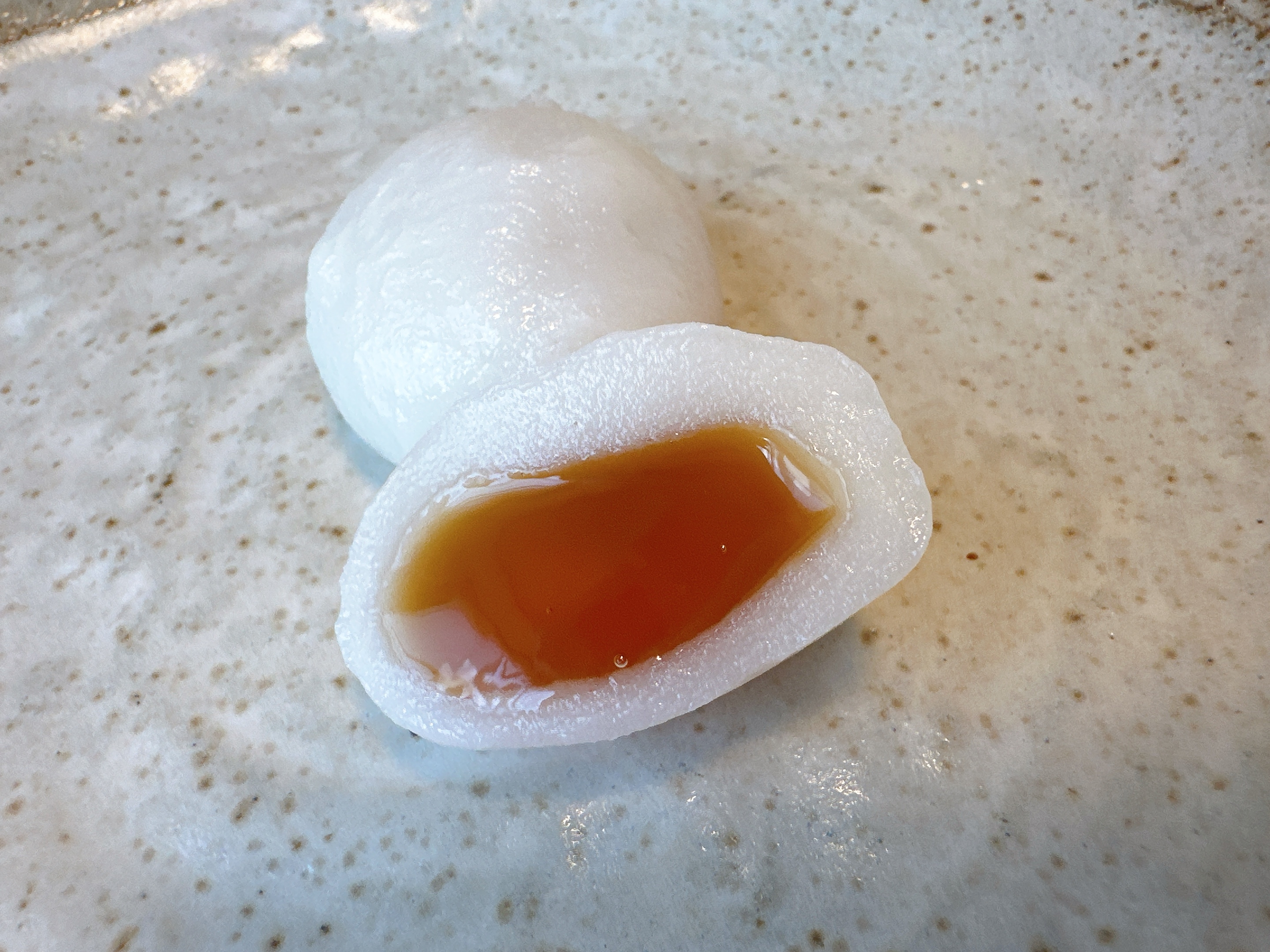 皿に餅の一部が切られ中が見える。中身はとろりとした液体状になっています。