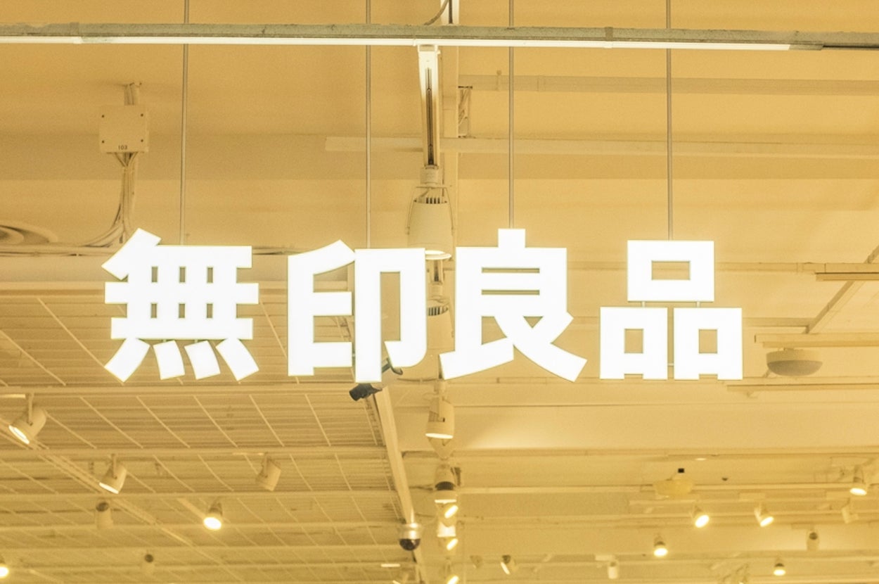 無印良品の店内の様子。棚に商品が並び、買い物をする人々がいる。