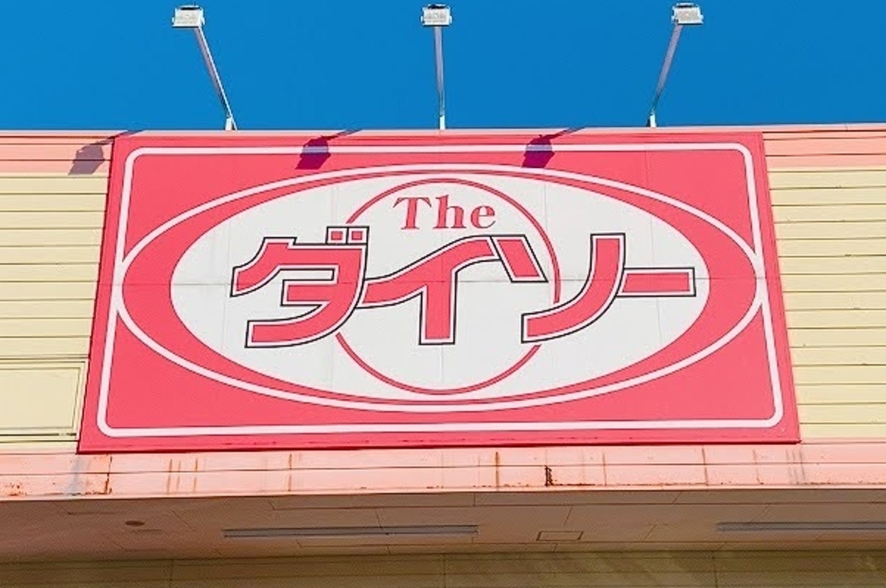 ダイソーの店舗入口。看板があり、多くの人々が出入りしている様子。