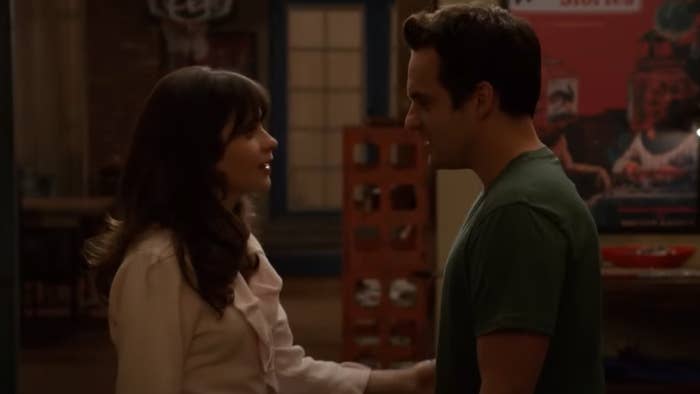 Nick and Jess in the show "New Girl" standing closely together, gazing at each other