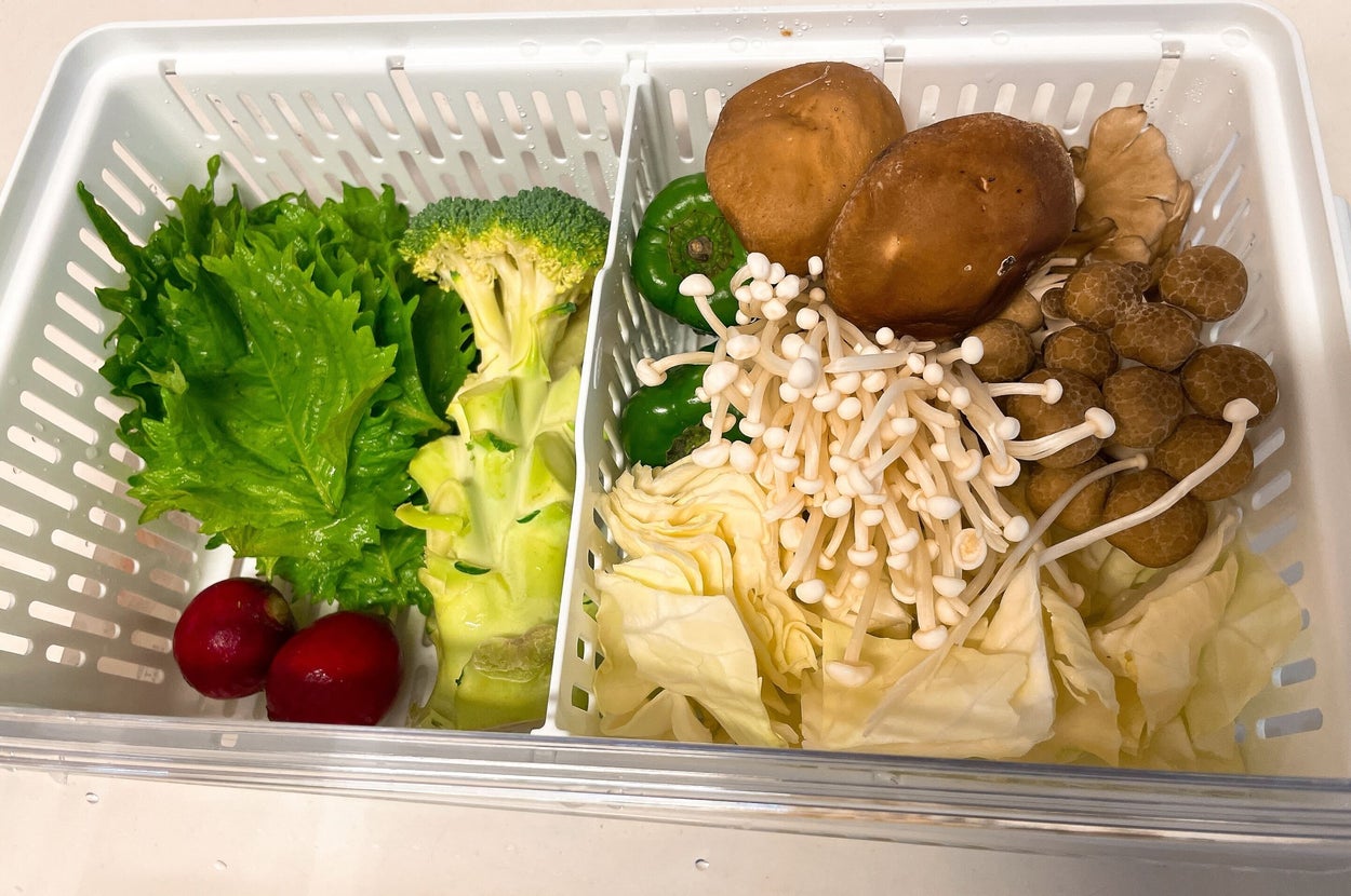 野菜バスケットに、レタス、ブロッコリー、ラディッシュ、ピーマン、しいたけ、えのき、しめじ、キャベツが入っている。