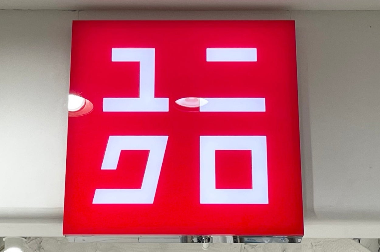 Illuminated sign with Japanese characters for "Uniqlo" in a retail store setting