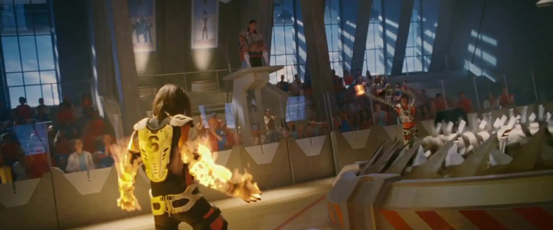 Futuristic sports arena with competitors in high-tech suits, one engulfed in flames, and spectators in the background