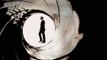 Silhouette of a man walking through a stylized gun barrel, reminiscent of a classic movie intro scene