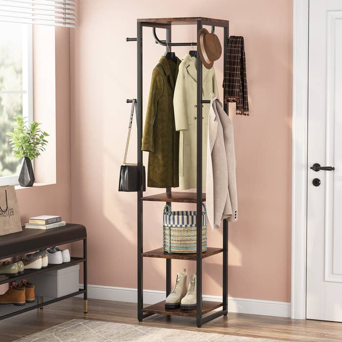 Coat rack with jackets, hats, scarves, a basket, and boots successful a tidy entryway