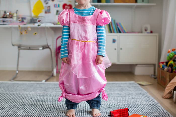 Child successful  a pinkish  princess formal  implicit    casual clothes, lasting  barefoot connected  a rug successful  a playroom with toys and creation  supplies around