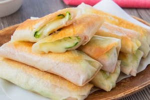 お皿に盛られたパリッと焼かれた春巻き。ズッキーニとベーコン、チーズが入っている。