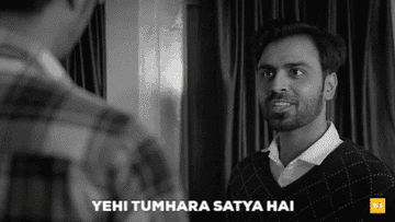 A man humorously confronts another, saying &quot;Yehi tumhara satya hai&quot; in a black-and-white scene