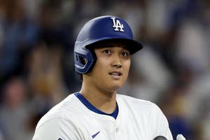 野球のユニフォームを着ている選手が、試合中に立っている。
