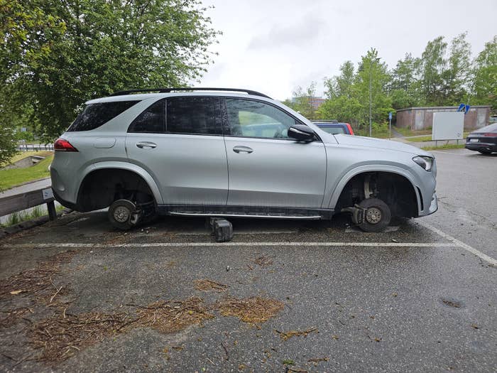SUV parked without wheels successful a lot, raised connected blocks