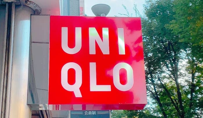 Uniqlo store sign on a building exterior with trees in the background