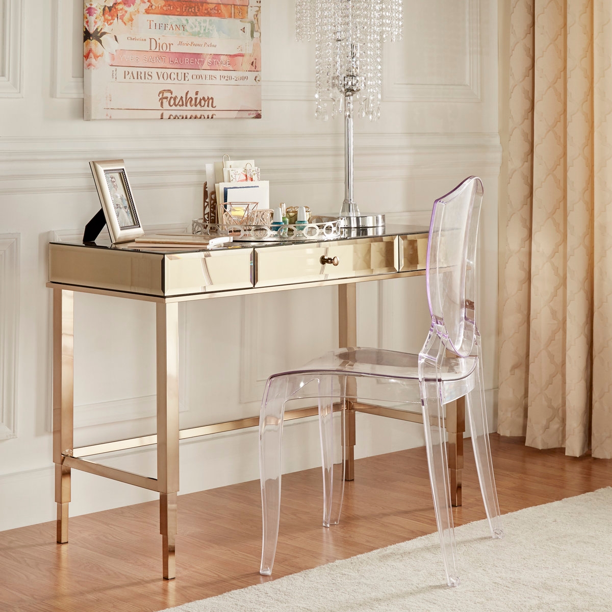 Chic vanity desk with transparent chair, adorned with a lamp, frames, and decor items, set in a stylish room with elegant curtains